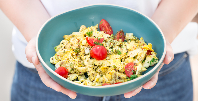 Rührei mit Tomaten in blauer Schüssel