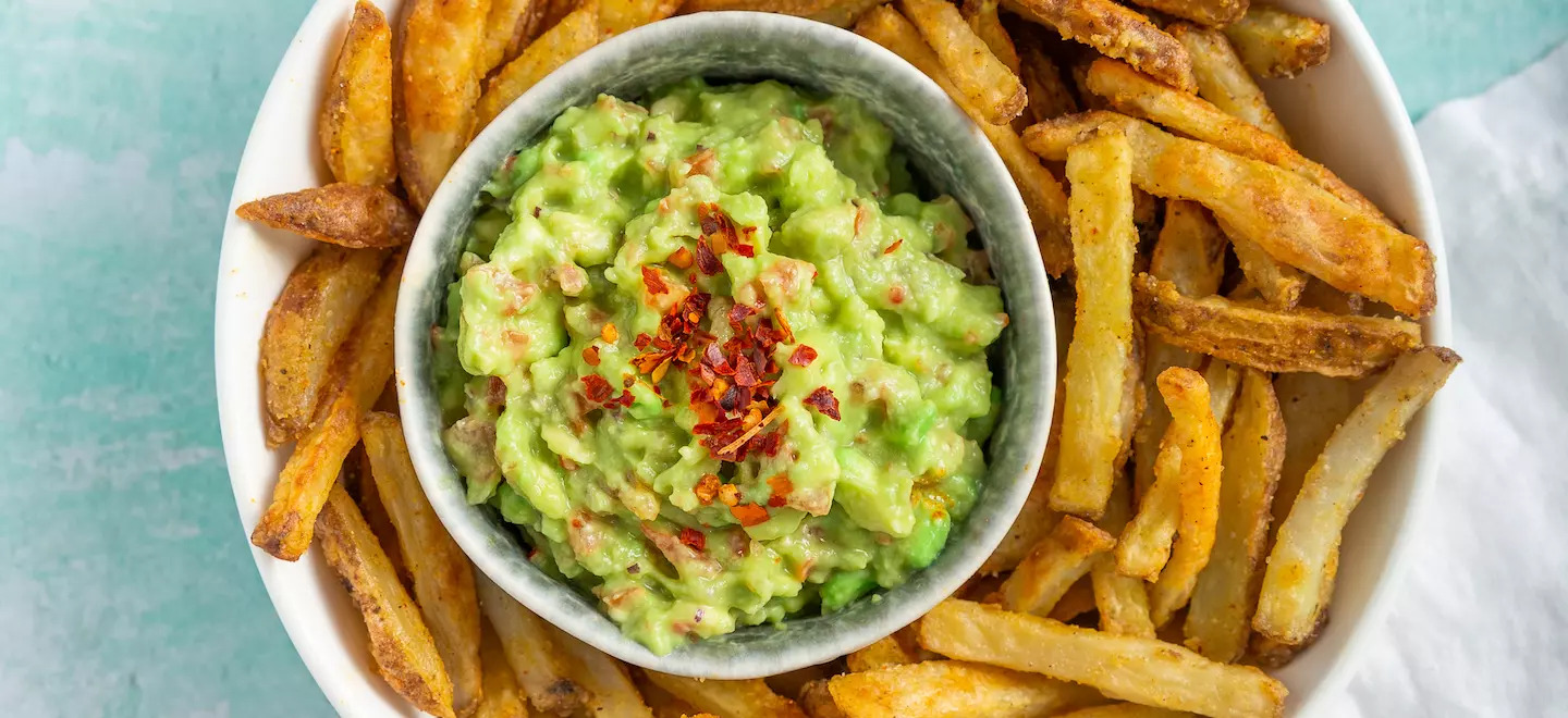 Selbstgemachte Pommes mit Guacamole in einer Schüssel 