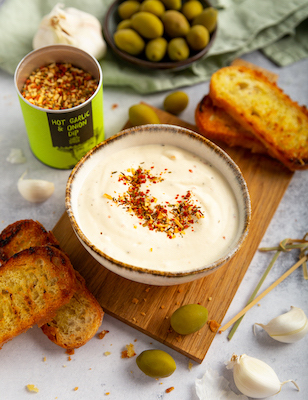 selbstgemachtes-aioli-in-einer-schüssel-mit-geröstetem-baguette-und-grünen-oliven