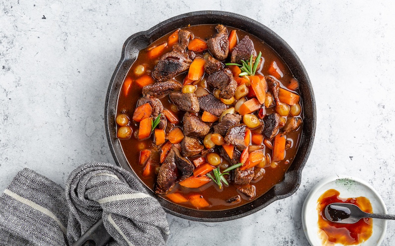 schnelles-fleischragout-mit-rosmarin-karotten-und-dunkler-sauce-in-einer-pfanne