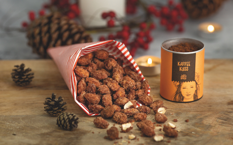 Gebrannte Mandeln in rote/weiß gestreifter Tüte gewürzt mit dem Just Spices Gewürz für Kaffee,  weihnachtlicher Hintergrund 