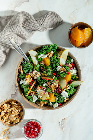 Grünkohl Salat mit Apfel, Orange, Walnüsse und Granatapfelkernen in einer Salat Schüssel 