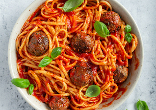 Spaghetti in Tomatensoße mit Häckbällchen und frischem Basilikum
