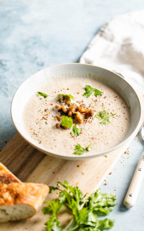 champignoncremesuppe-in-einer-weißen-schale-mit-liebstöckel-gewürz