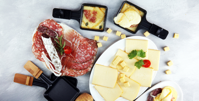 raclette-zutaten-wie-salami-und-käse-auf-platten-angerichet