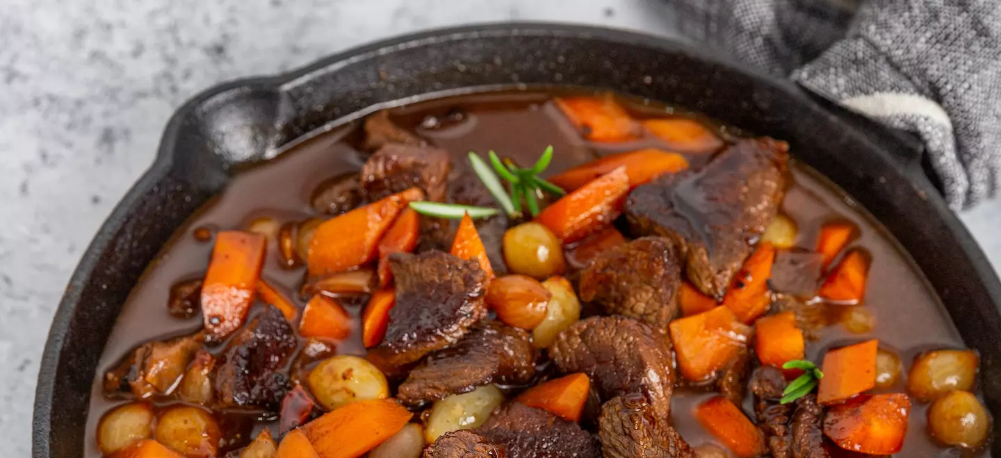 schnelles-fleischragout-mit-rosmarin-karotten-und-dunkler-sauce-in-einer-pfanne