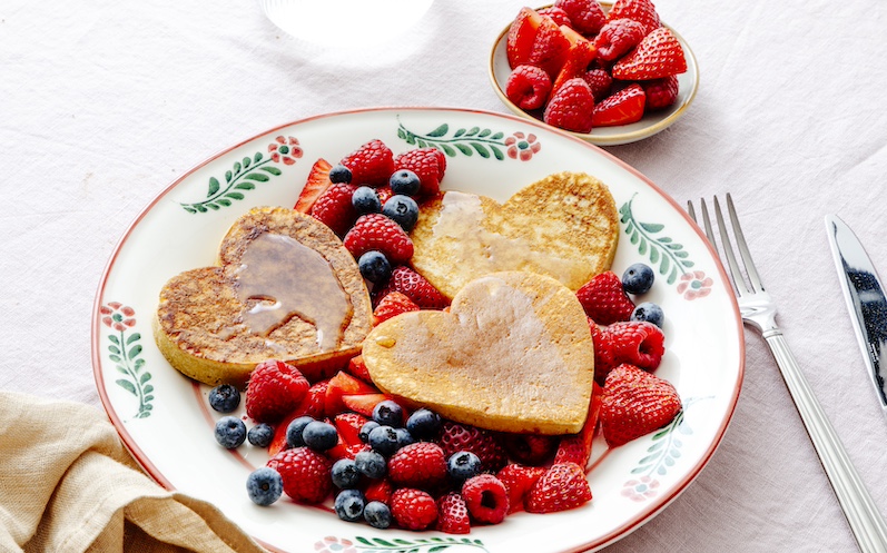 Pancakes in Herzform mit Beeren und Ahornsirup 