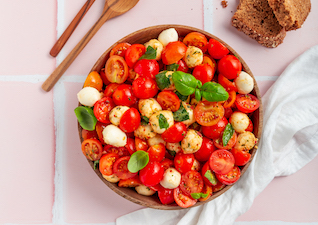 Tomate Mozzarella Salat mit Basilikum in Holzschüssel