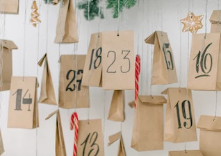 selbstgemachte-beschriftete-adventskalender-tuetchen-an-einer-wand