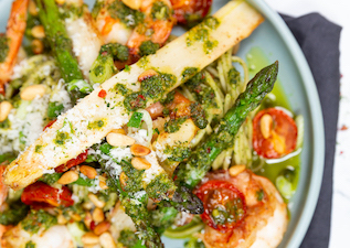 Nahaufnahme von Spaghetti mit Bärlauchpesto, Spargel, Cherrytomaten und Garnelen