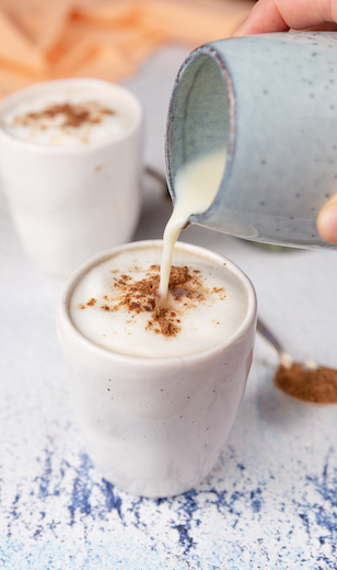 Tasse mit Milchschaum und Pumpkin Pie Spice dekoriert