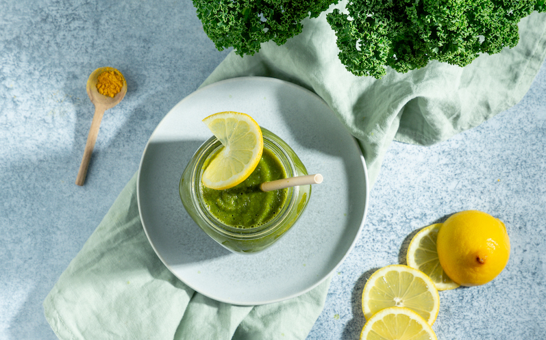 gruenkohl-smoothie-mit-zitronenscheiben-dekoriert-in-einem-glas-mit-strohhalm