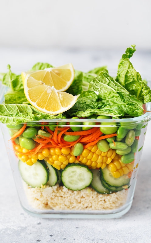Veganer Meal Prep Salat in einer Dose darunter Quinoa, Mais, Gurke, Möhre, Salat und Edamame Bohnen 