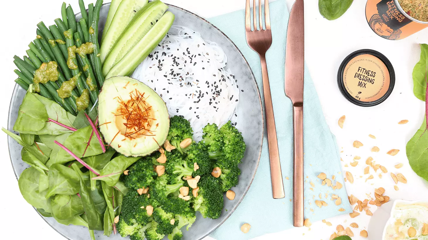 gruener-salat-mit-avocado-kernen-und-fitnessdressing-mix-dekoriert