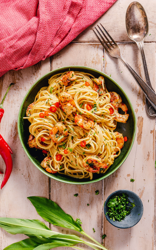 spaghetti-mit-knoblauch-chili-und-gebratenen-garnelen-in-einer-schale-dekoriert